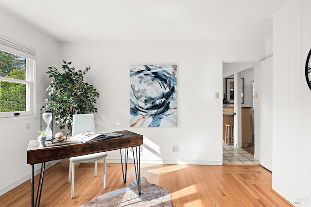 home office featuring baseboards and light wood finished floors