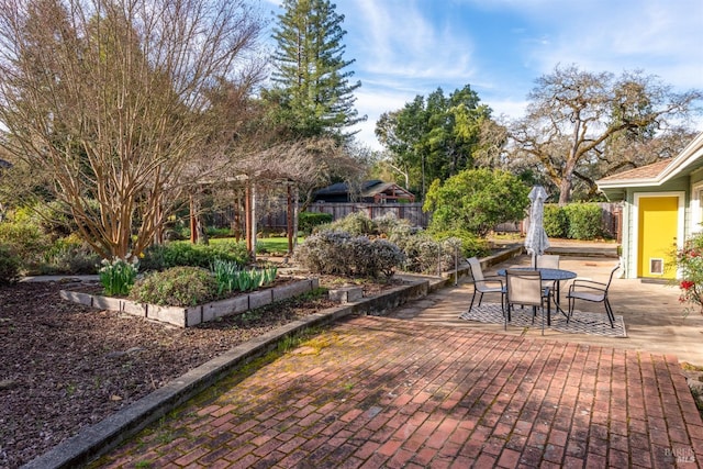 view of patio featuring outdoor dining space and fence