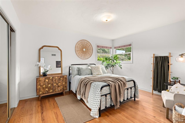 bedroom featuring visible vents, a closet, light wood-style flooring, and baseboards