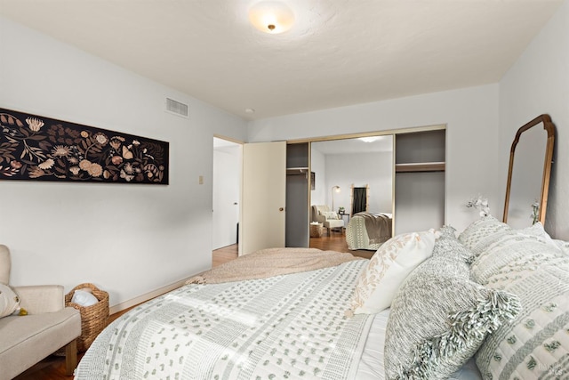 bedroom featuring a closet, wood finished floors, and visible vents