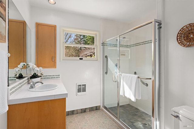 bathroom with toilet, a stall shower, tile patterned flooring, and vanity