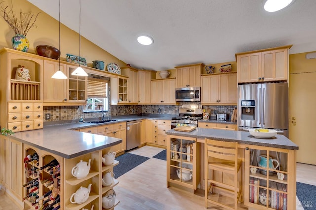 kitchen featuring dark countertops, stainless steel appliances, open shelves, and a sink