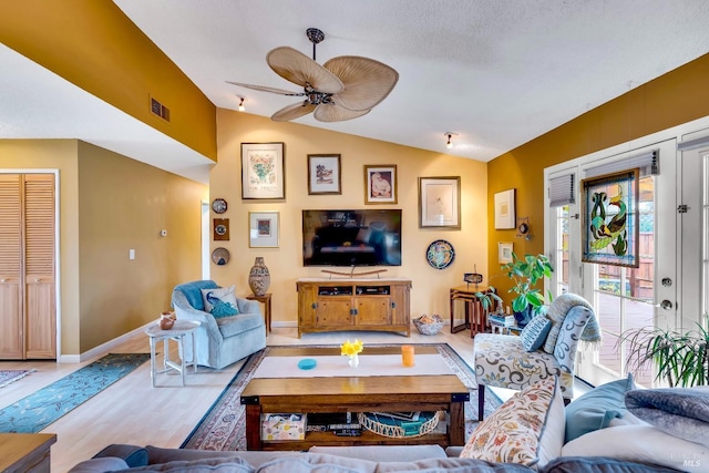 living area with light wood finished floors, lofted ceiling, visible vents, a ceiling fan, and baseboards