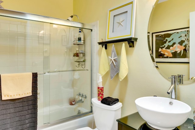 full bath featuring toilet, combined bath / shower with glass door, and vanity