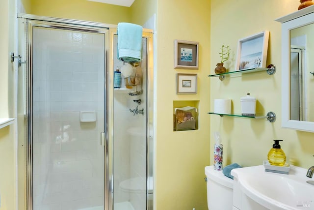 full bathroom featuring a stall shower, a sink, and toilet