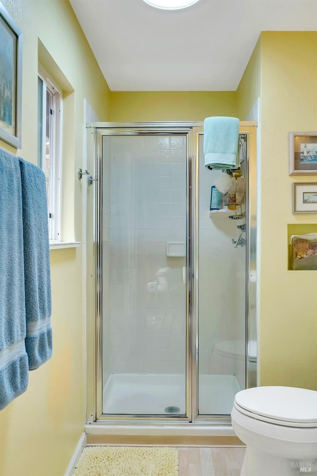 full bath featuring toilet and a stall shower