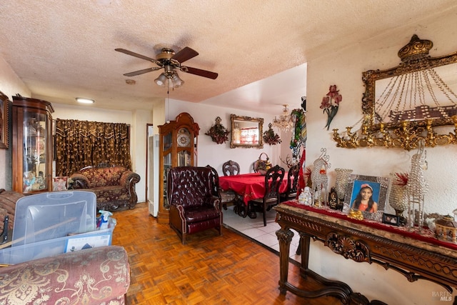 living area with a ceiling fan and a textured ceiling