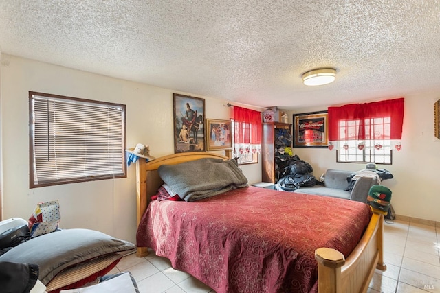 bedroom featuring light tile patterned floors and a textured ceiling