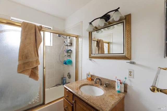 bathroom featuring combined bath / shower with glass door and vanity