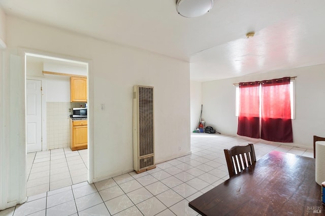 dining area with a heating unit and light tile patterned floors