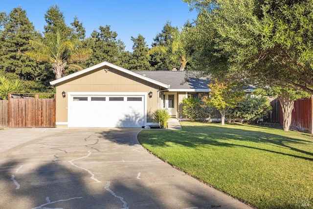 ranch-style home with driveway, a garage, fence, and a front yard