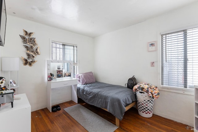 bedroom with baseboards and wood finished floors