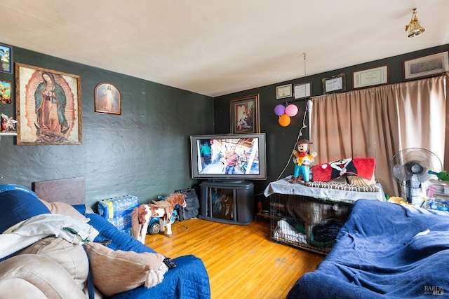 living room featuring a textured wall and wood finished floors