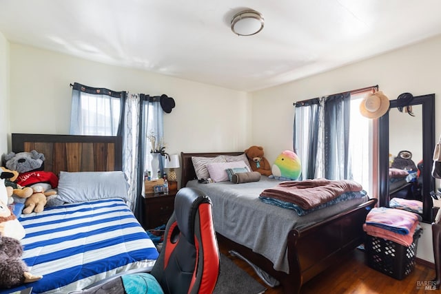 bedroom featuring multiple windows and wood finished floors