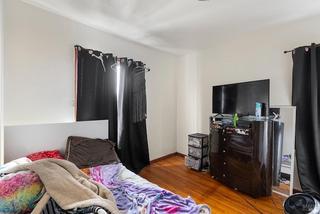 bedroom featuring baseboards and wood finished floors