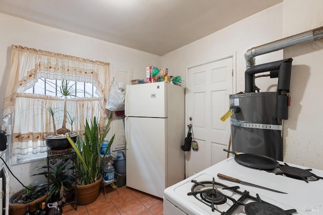 kitchen with light tile patterned flooring and freestanding refrigerator