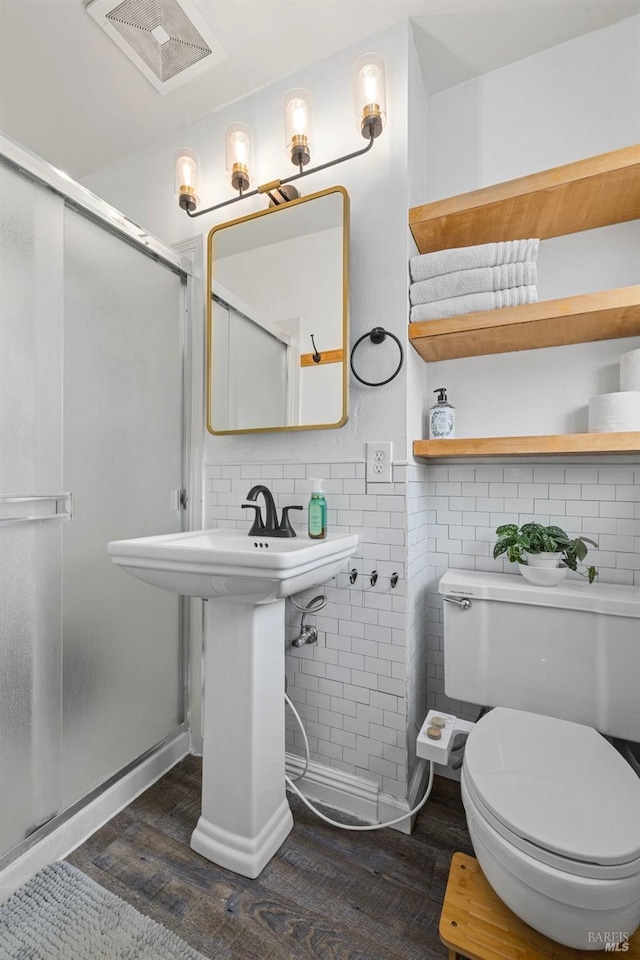 full bathroom with visible vents, a shower stall, toilet, and wood finished floors