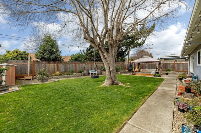 view of yard featuring an outbuilding, a gazebo, a patio area, and a fenced backyard