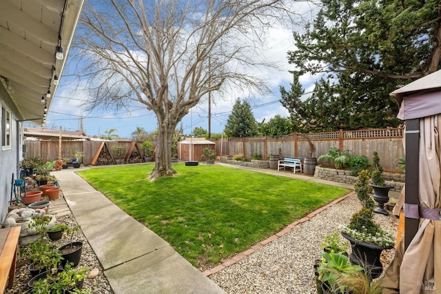 view of yard with an outbuilding, a patio, and a fenced backyard