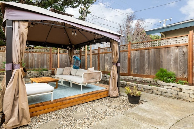 view of patio / terrace featuring a fenced backyard, an outdoor living space, and a gazebo