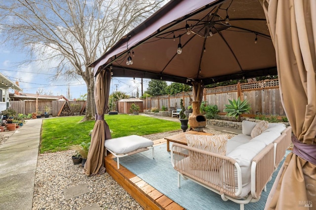 view of patio featuring outdoor lounge area, an outdoor structure, a fenced backyard, and a gazebo