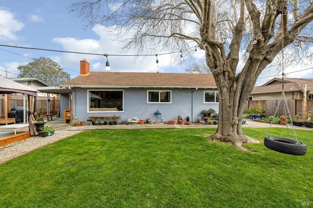 view of front of house with a chimney, fence, a gazebo, a patio area, and a front yard