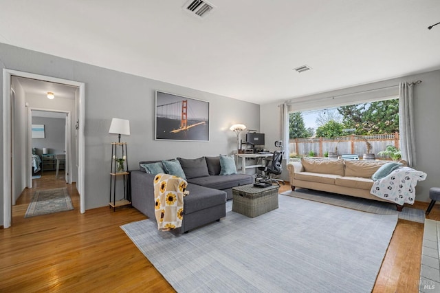 living area featuring light wood-type flooring and visible vents