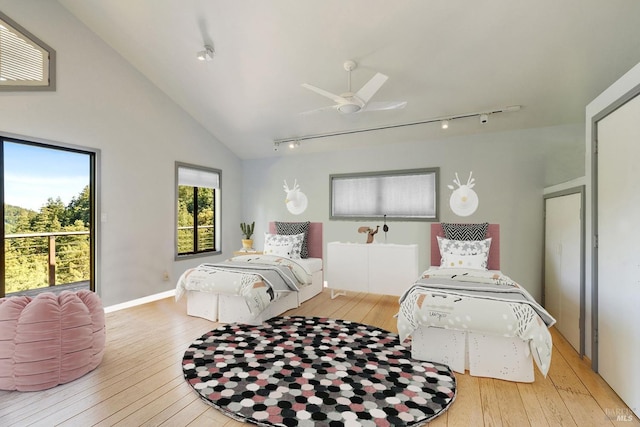 bedroom with baseboards, rail lighting, ceiling fan, and hardwood / wood-style floors