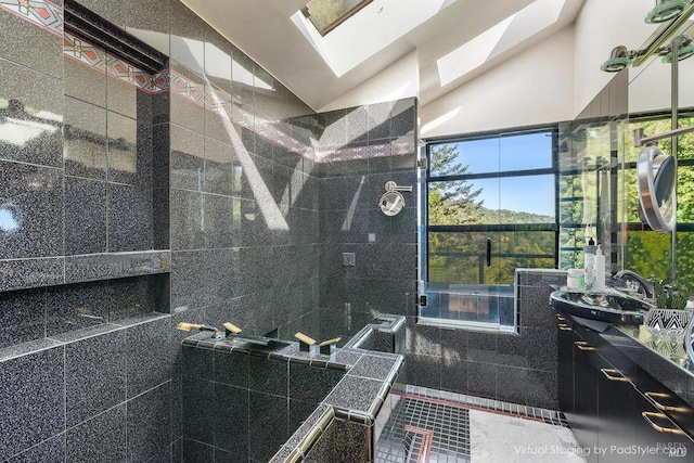 full bath featuring a sink, lofted ceiling with skylight, a walk in shower, and a wealth of natural light