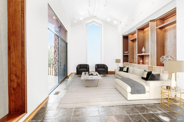 living area featuring lofted ceiling, visible vents, and baseboards