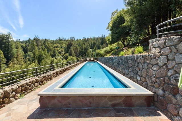 view of pool with a view of trees