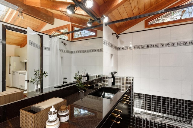 kitchen with lofted ceiling with beams, wooden ceiling, tile walls, and a sink