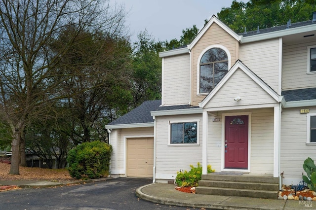 view of front of home featuring a shingled roof, an attached garage, and aphalt driveway