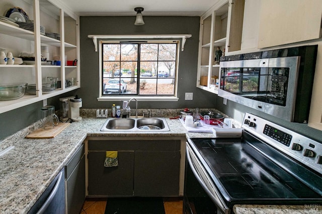 kitchen with stainless steel appliances, tile patterned flooring, a sink, and light countertops