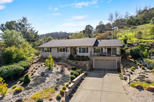 ranch-style home featuring driveway, stairway, and an attached garage