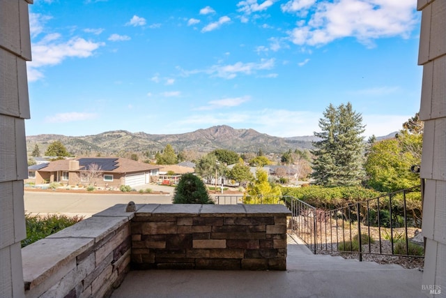 view of patio with fence and a mountain view