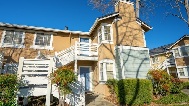 view of front of house with a balcony and stucco siding