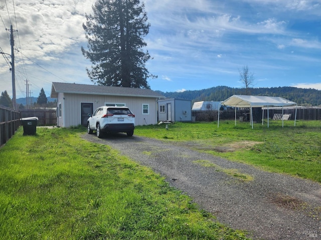 exterior space with driveway, a front lawn, and fence