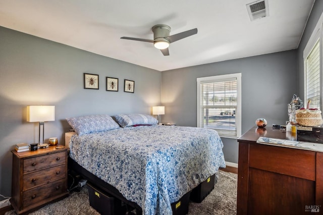 bedroom featuring visible vents, multiple windows, a ceiling fan, and baseboards