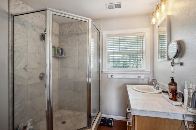 bathroom featuring visible vents, baseboards, vanity, and a shower stall