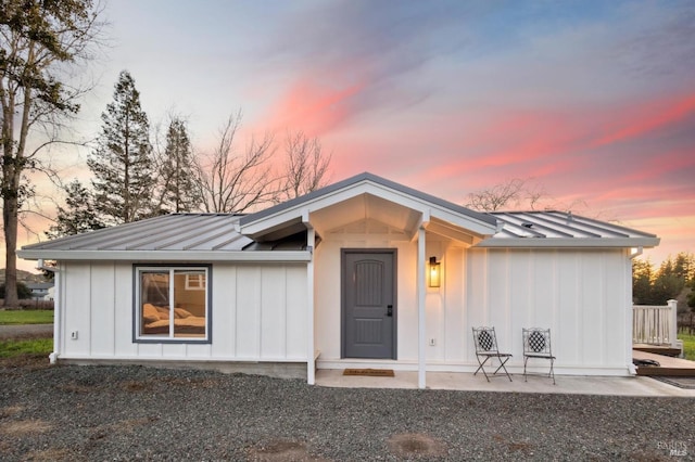 view of front facade featuring board and batten siding, metal roof, and a standing seam roof