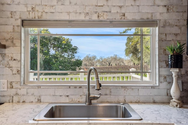 room details with a sink and light stone countertops