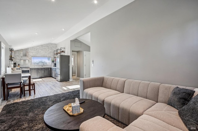 living area with light wood-style flooring and high vaulted ceiling