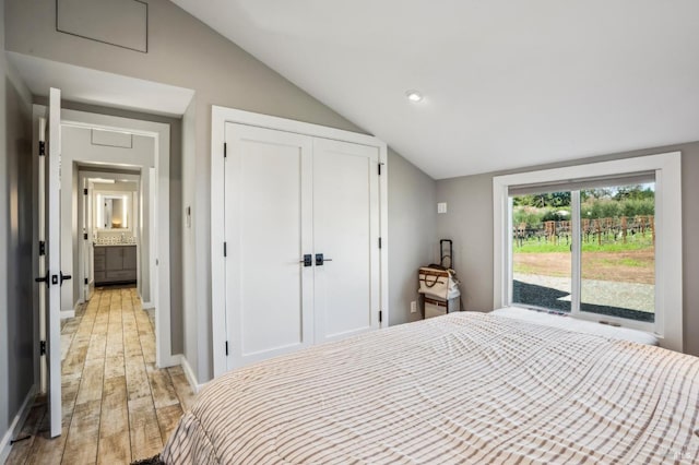 bedroom with baseboards, lofted ceiling, recessed lighting, a closet, and light wood-type flooring