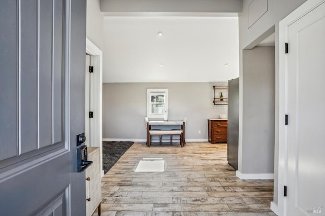 foyer entrance with wood finished floors and baseboards