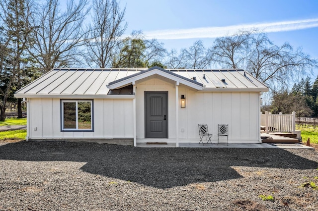 view of front facade with board and batten siding, metal roof, and a standing seam roof