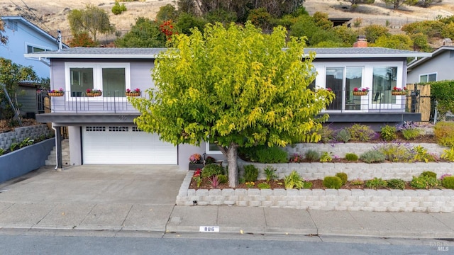 view of front facade with a garage, concrete driveway, and french doors