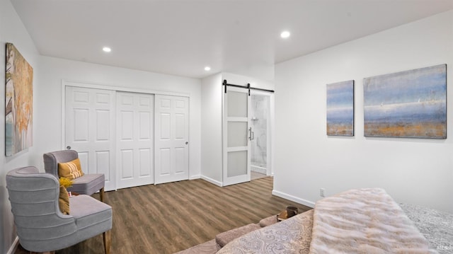 living area featuring a barn door, baseboards, wood finished floors, and recessed lighting