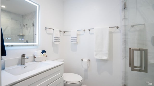 bathroom featuring toilet, a stall shower, and vanity