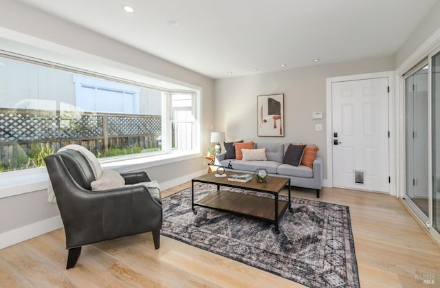 living room with light wood finished floors, baseboards, and recessed lighting